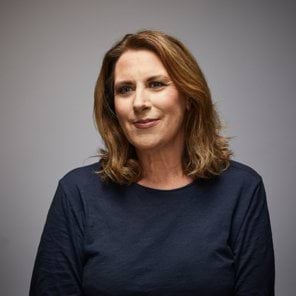 Rose's story Image of current police officer smiling to the left of camera wearing navy blue smart casual top. Late forties, female with light skin and shoulder-length light brown hair.