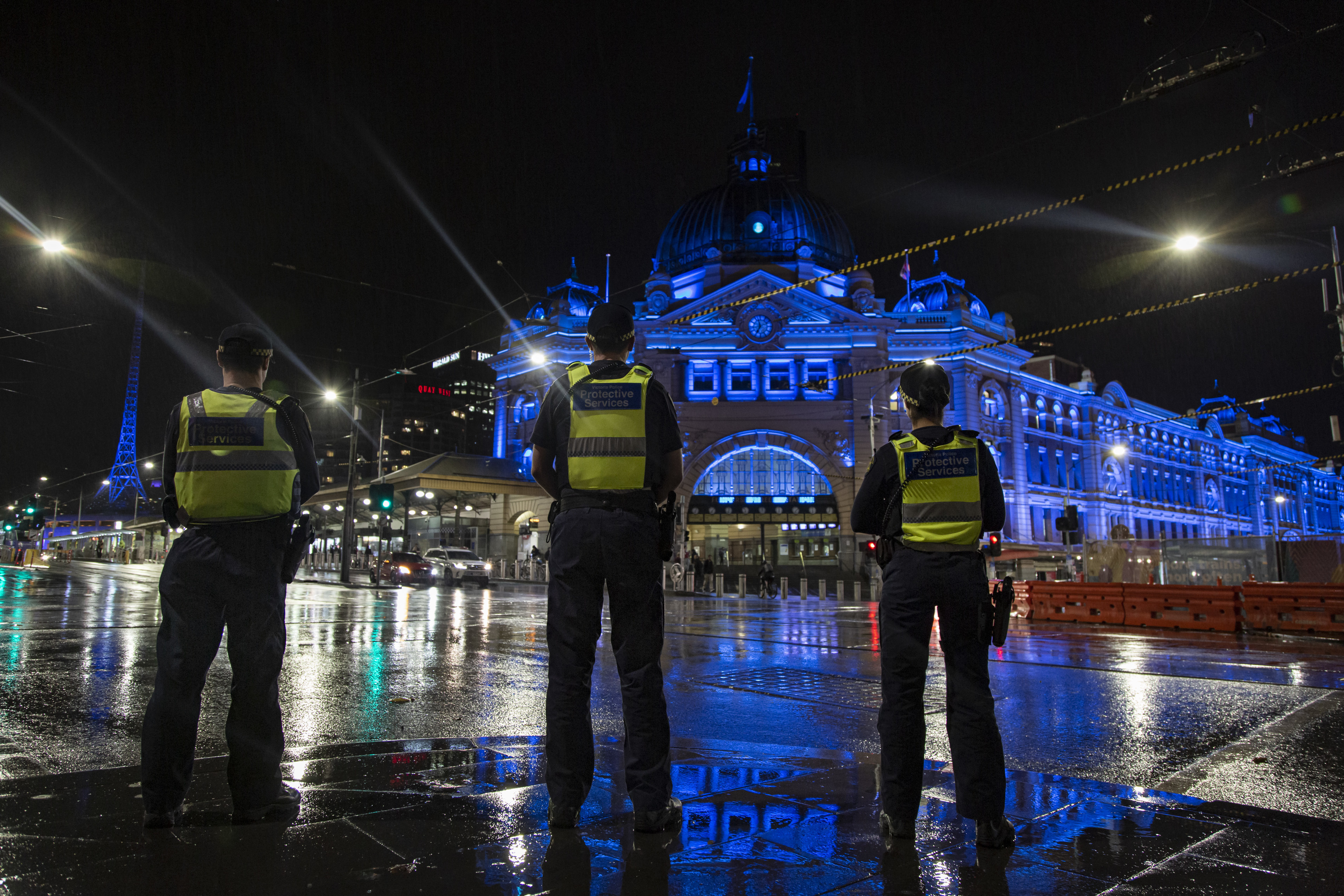 Protective services officers outside Flinders St Station, Melbourne Protective services officers outside Flinders St Station, Melbourne at night. The station has been lit with blue lighting as a tribute following the Kew tragedy
